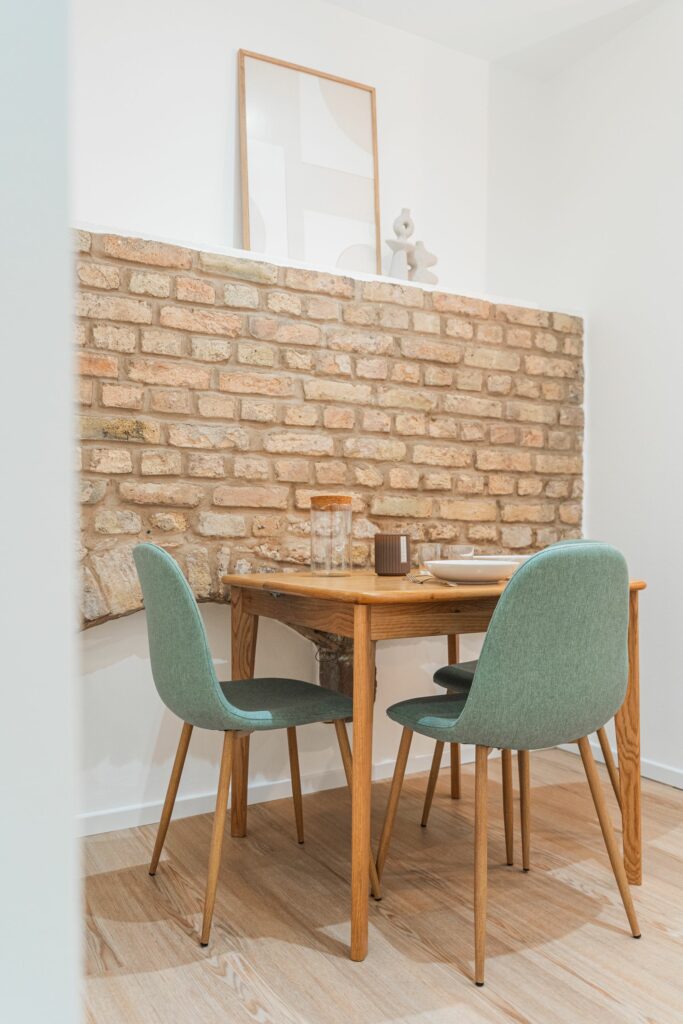 Le parement en pierre avec table de repas de cet appartement bourguignon de caractère