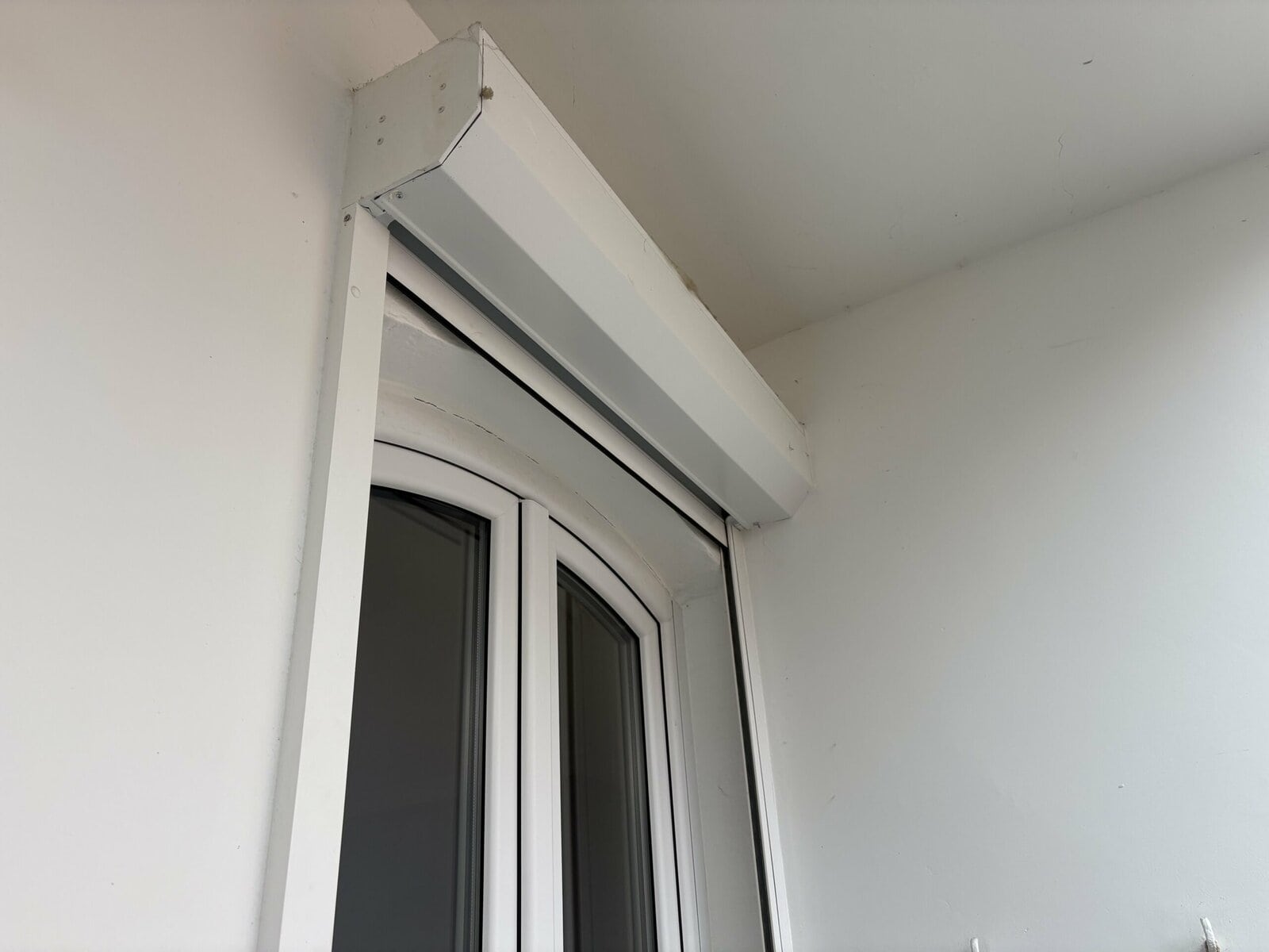 caisson de volet installé à l'extérieur pour une fenêtre pvc cintrée