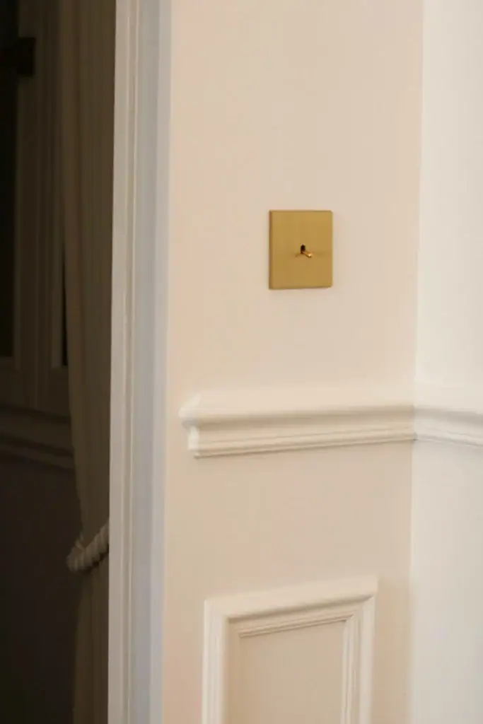 Interrupteur en laiton brossé au sein de notre projet Showroom Niméa par nos designer d'intérieur de Cannes.