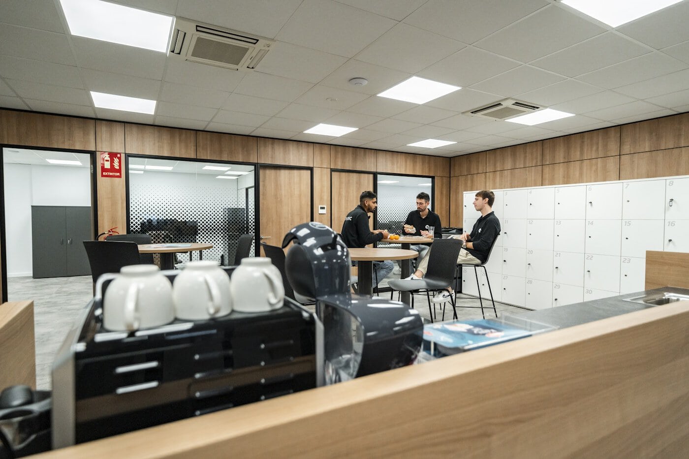 Three people are chatting in a modern office space.