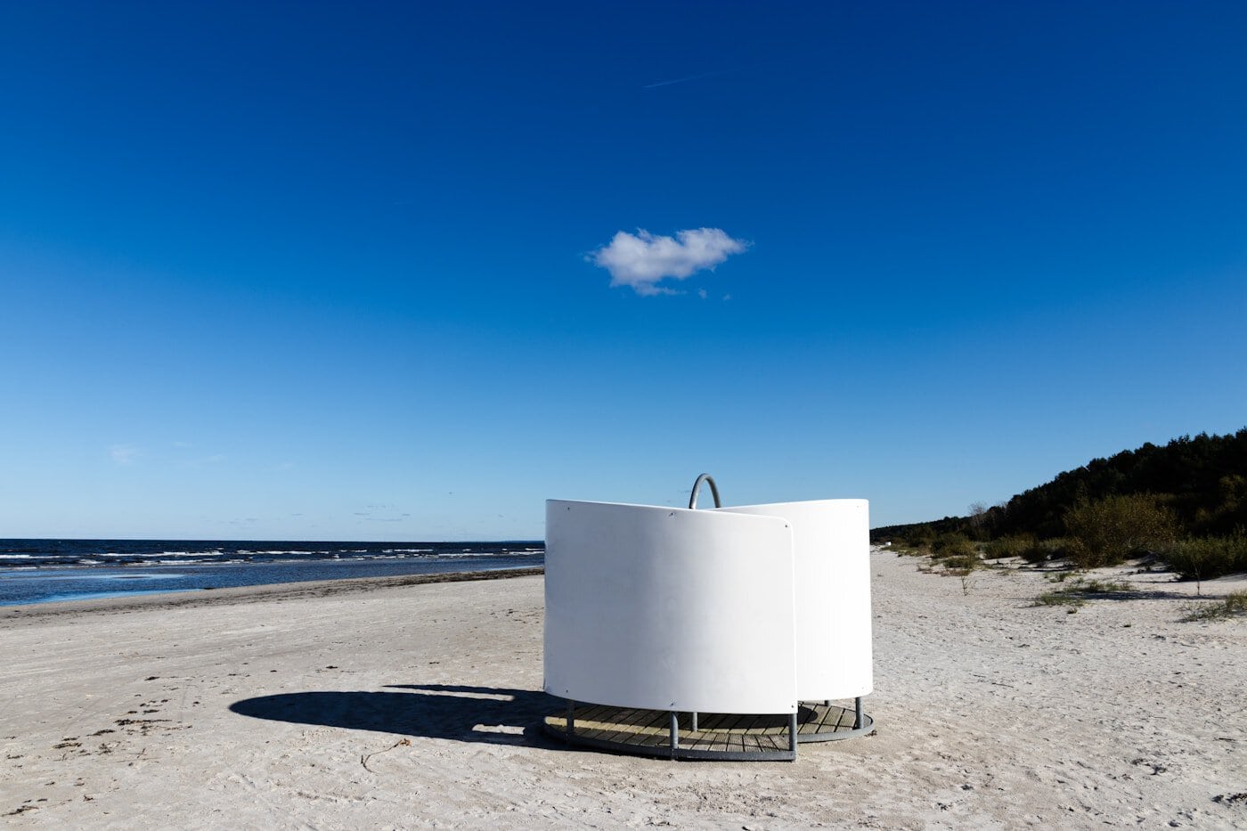 White structure on a sandy beach under blue sky