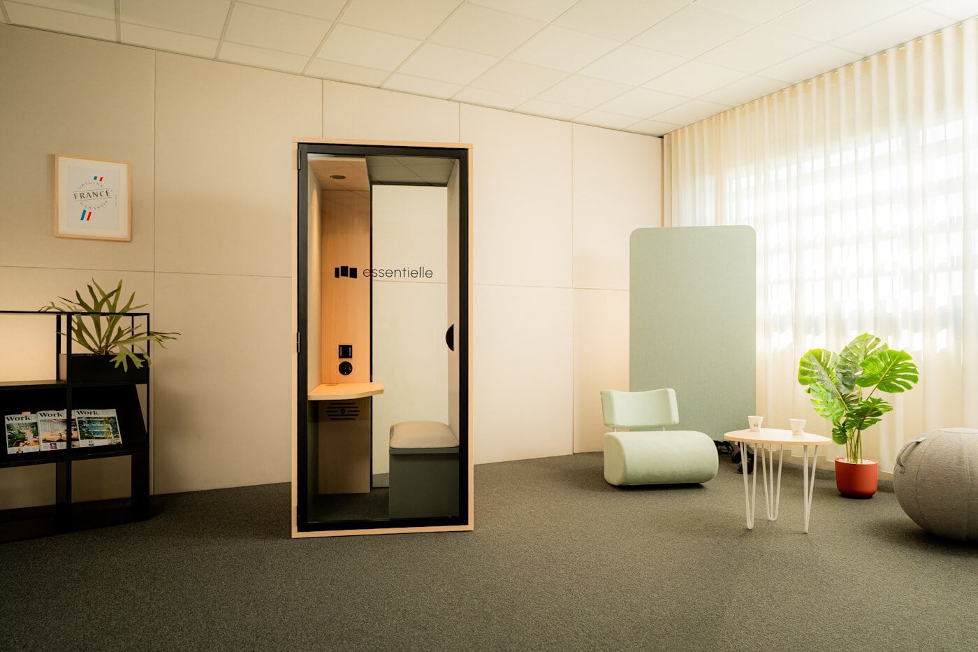 Modern office with soundproof phone booth and seating.